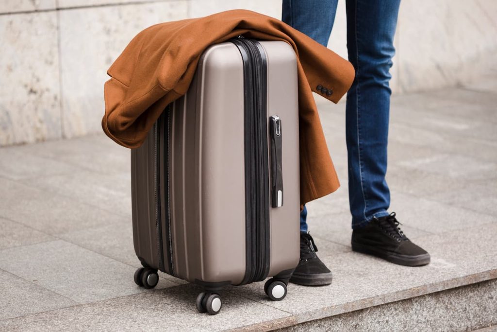 Homme à côté de sa valise